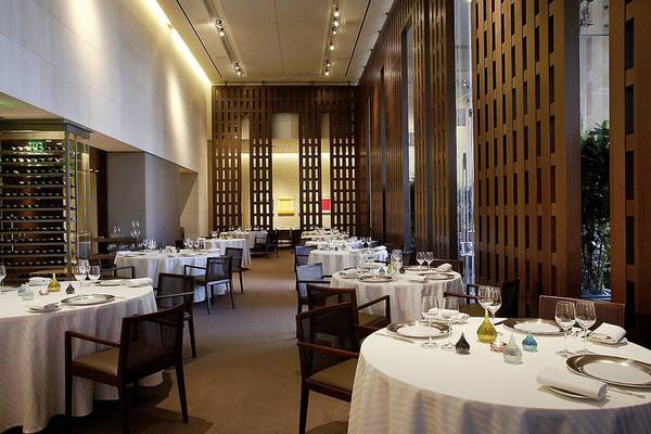Ein elegantes Restaurant im Caesars Palace mit weißen Tischdecken, Glasflaschen und Holzwänden.