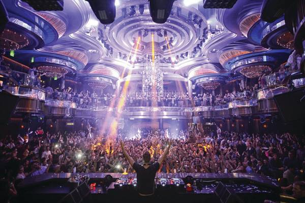 Ein DJ tritt auf der Bühne des Caesars Palace auf, umgeben von einem großen Publikum und leuchtenden Lichtern.
