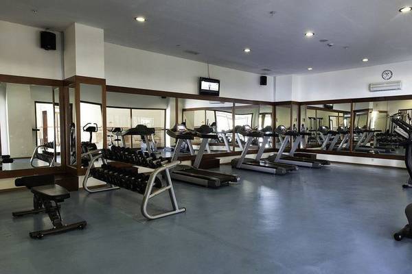Fitnesscenter im Adalya ArtSide Hotel mit verschiedenen Geräten und Spiegeln.