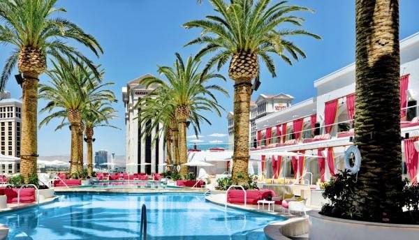 Poolbereich im The Cromwell Las Vegas Hotel & Casino mit roten Sonnenliegen und Palmen