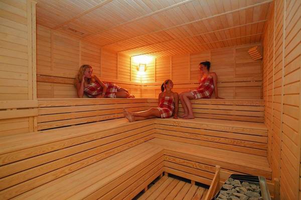 Drei Frauen in einem Holzsaunaraum des Monachus Hotel & Spa