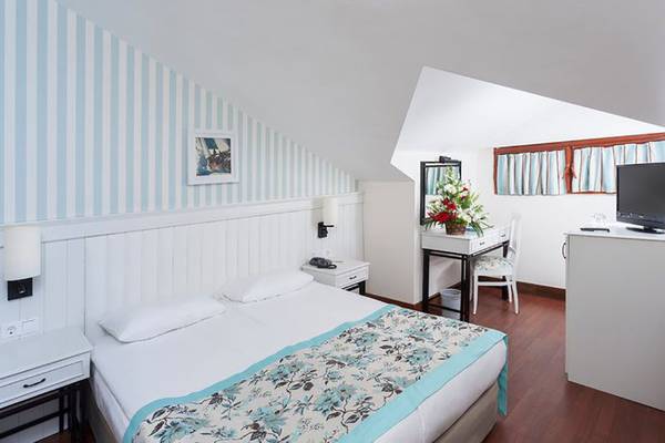 Schlafzimmer des Monachus Hotel & Spa mit Doppelbett, Dekor und Fenstern.
