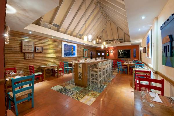 Innenansicht des Restaurants im Viva Wyndham Dominicus Palace Hotel mit Holzwänden und bunten Stühlen.