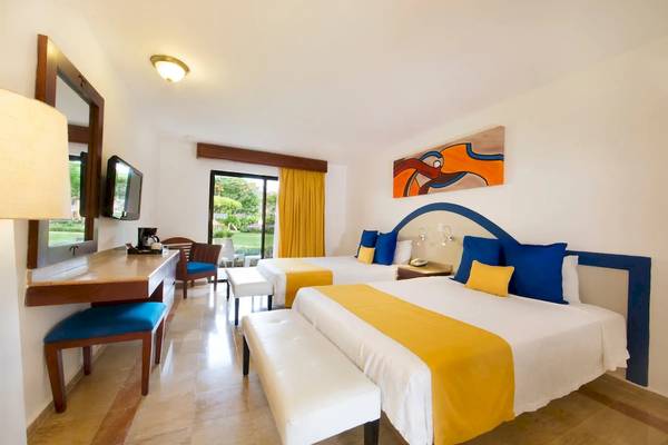 Viva Wyndham Dominicus Palace Hotel Zimmer mit zwei Betten, Schreibtisch und Möbeln.