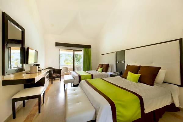 Doppelzimmer im Viva Wyndham Dominicus Palace Hotel mit zwei Betten, Schreibtisch und Balkon.
