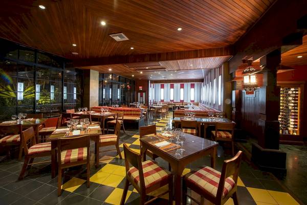Innenansicht des Restaurants im Viva Wyndham Dominicus Palace Hotel mit holzvertäfelten Wänden und gelben Bodenfliesen.