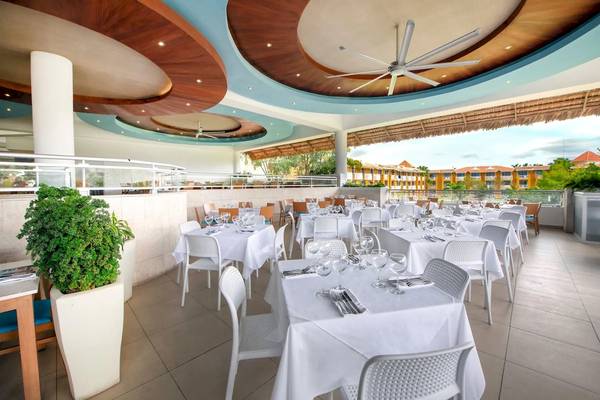 Innenansicht des Restaurants im Viva Wyndham Dominicus Palace Hotel mit gedeckten Tischen und Stühlen.