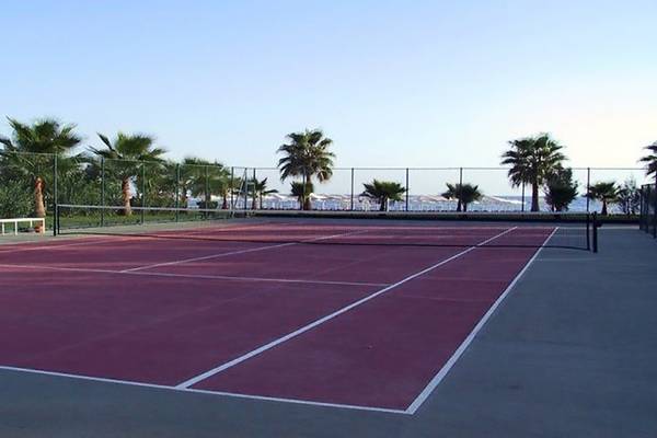 Tennisplatz im Miramare Beach Hotel mit Blick auf das Meer und Palmen