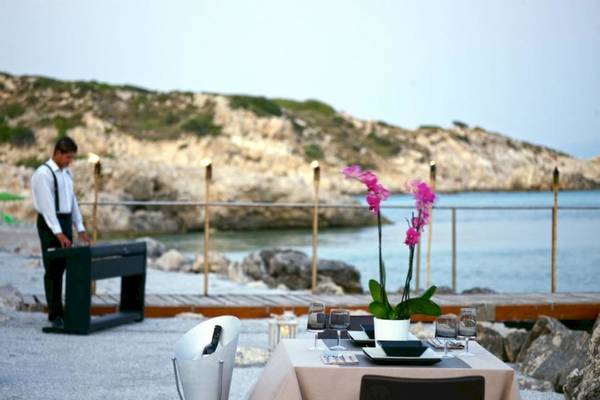 Abendessen am Strand im Proteas Blu Resort mit Blick auf das Meer und eine Felsenküste.