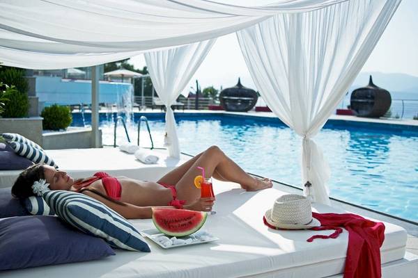 Frau im roten Bikini am Pool unter Baldachin im Proteas Blu Resort