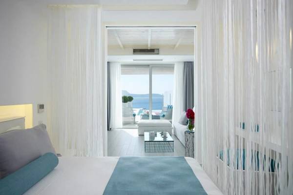 Das Schlafzimmer im Proteas Blu Resort mit Blick auf das Meer und modernen Inneneinrichtungen.