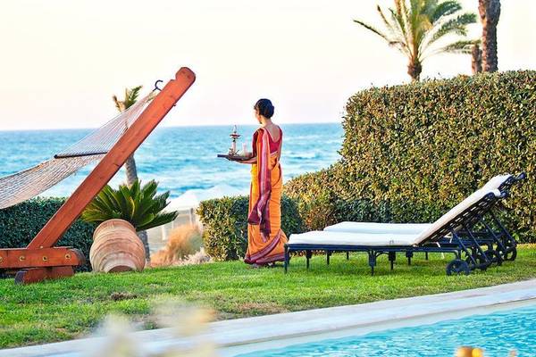 Frau im Saree hält eine Schale mit einem Wasserpfeifen am Pool, Blick auf das Meer, Grecotel Olympia Oasis Aqua Park
