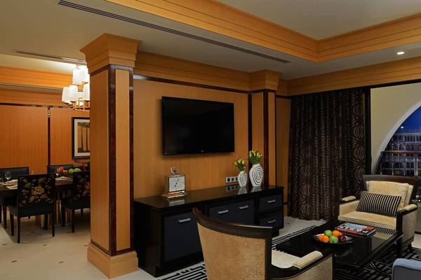 Inneneinrichtung der Hotelsuite im Ritz Carlton Abu Dhabi Grand Canal mit Fernseher und Esstisch.
