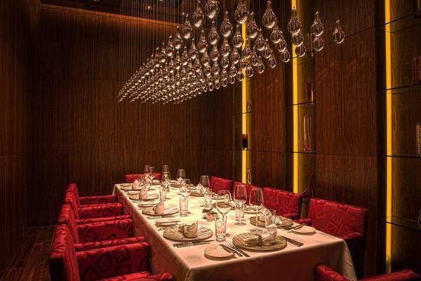 Das Esszimmer des Ritz Carlton Abu Dhabi Grand Canal mit rotem Interieur und hängenden Lampen.