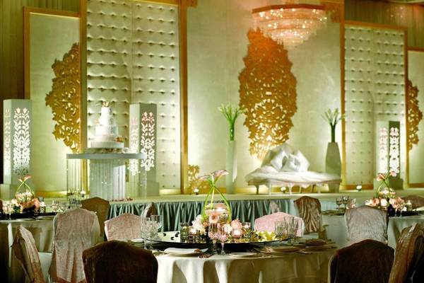 Bankettsaal im Ritz Carlton Abu Dhabi Grand Canal mit üppiger Dekoration und zentralem Tisch mit Kerzen und Blumen.