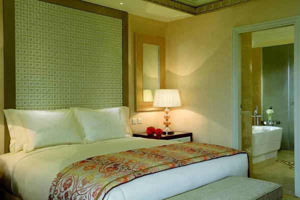 Luxuriöses Schlafzimmer im Ritz Carlton Abu Dhabi Grand Canal mit einem großen Bett, Nachttisch und Badewanne.