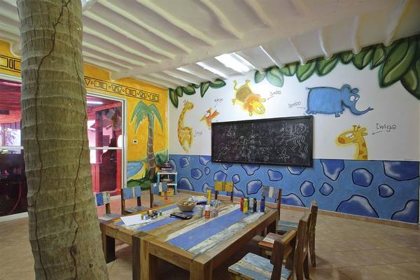 Innenansicht des Kinderzimmers im Bluebay Beach Resort & Spa mit blauen und gelben Wänden, gemalten Tieren und einem Schreibtisch.