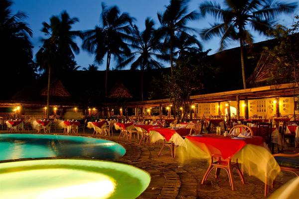 Bluebay Beach Resort & Spa Restaurant mit Pool und Tischen im Freien bei Nacht