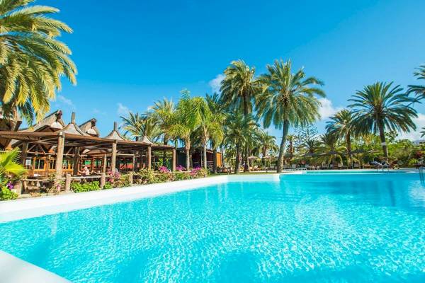 Außenpool des HL Miraflor Suites Hotels umgeben von Palmen und Gebäuden