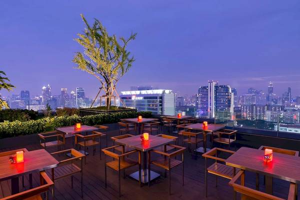 Beleuchtete Dachterrasse mit Tischen und Stühlen im Mercure Bangkok Siam Hotel
