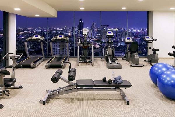 Fitnesscenter-Innenbereich im Mercure Bangkok Siam mit Blick auf die Stadt