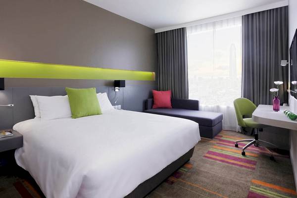 Hotelzimmer im Mercure Bangkok Siam mit Bett, Sofa, Schreibtisch und Stadtblick