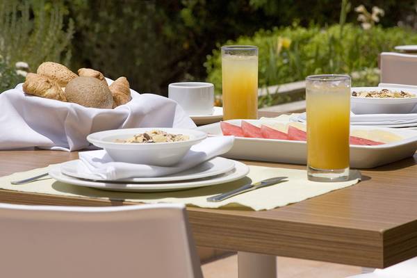 Frühstückstisch im Venus Beach Hotel mit Brot, Orangensaft und Müsli.