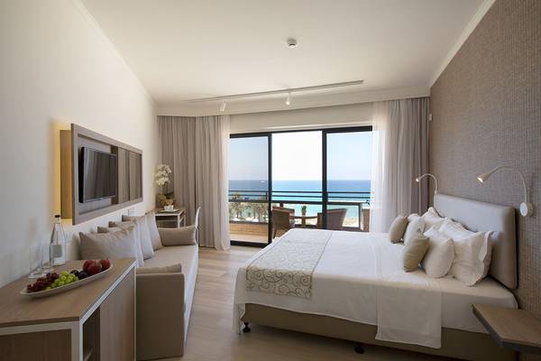 Suite-Zimmer im Venus Beach Hotel mit Meerblick, Doppelbett, Sofa und Balkon.