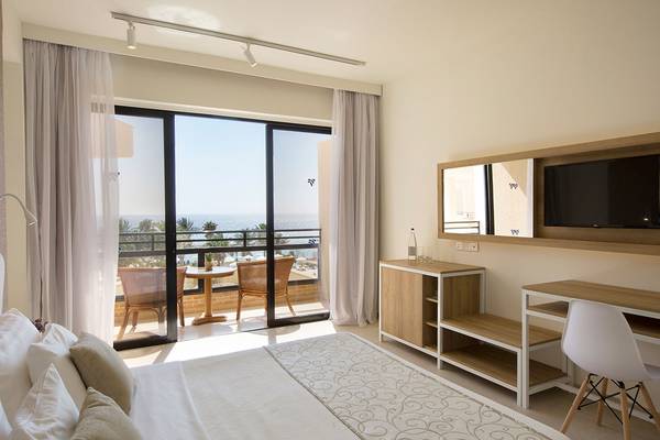 Zimmer im Venus Beach Hotel mit Blick auf das Meer und einen Balkon.