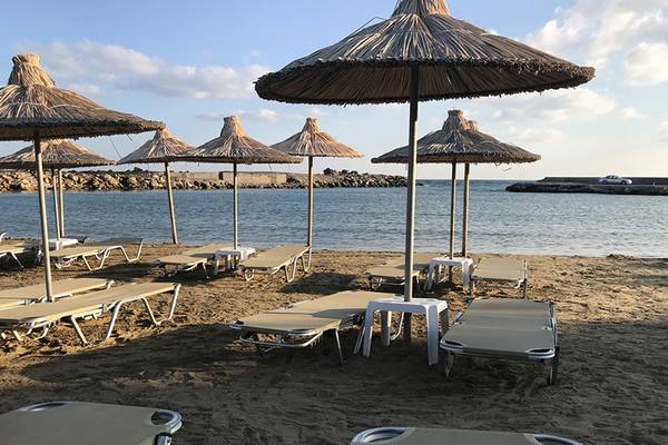 Strandszene mit Sonnenliegen und Palmen am Aphrodite Beach Club