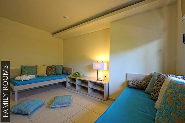 Familienzimmer im Aphrodite Beach Club mit zwei Betten, Lampen und Dekor.