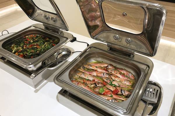 Zwei Edelstahl-Buffet-Schalen im Aphrodite Beach Club mit Gemüse und Fisch