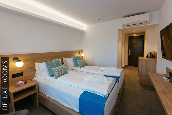 Doppelzimmer im Aphrodite Beach Club Hotel mit zwei Betten, Dekor und Fernseher.