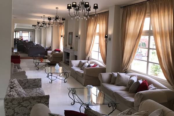 Lobby des Aphrodite Beach Club Hotels mit Sofas, Tischen und Kronleuchtern.