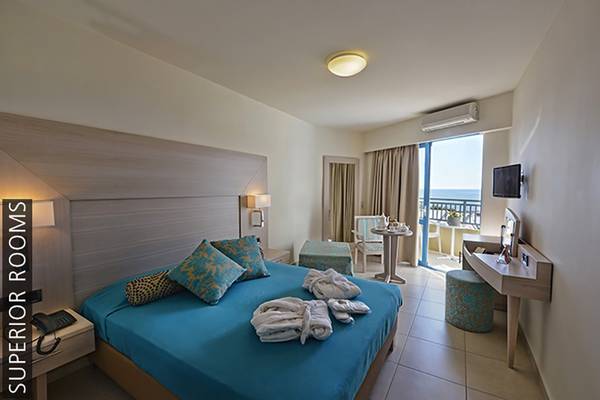 Superior Zimmer im Aphrodite Beach Club mit Meerblick und eingerichtetem Bett.