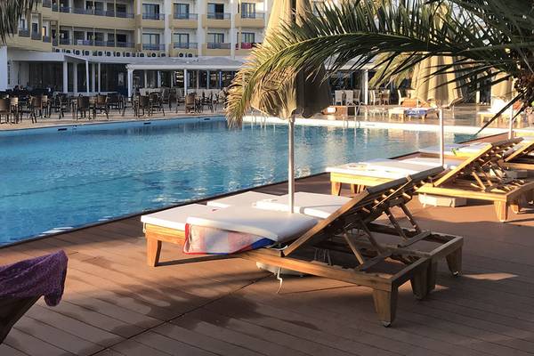Poolbereich des Aphrodite Beach Club Hotels mit Loungestühlen und Sonnenschirmen