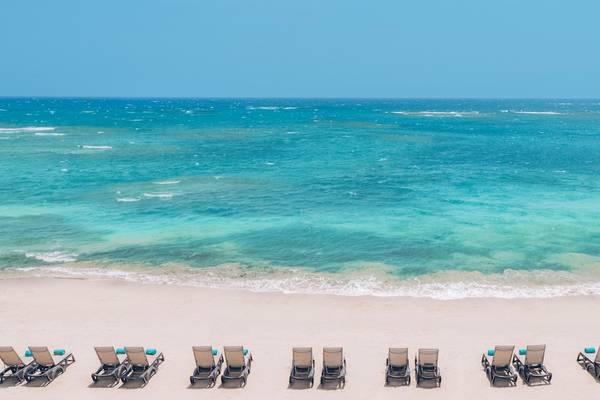 Reihe von Liegestühlen am Strand des Iberostar Costa Dorada Hotels mit Blick auf das Meer