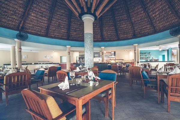 Innenansicht des Restaurants im Iberostar Costa Dorada Hotel mit runden Tischen und Stühlen.