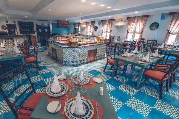 Innenansicht des Restaurants im Iberostar Costa Dorada Hotel mit blauen Fliesen und Holzstühlen.