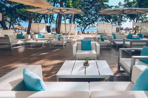 Loungebereich des Iberostar Costa Dorada Hotels mit weißen Möbeln und blauen Kissen.