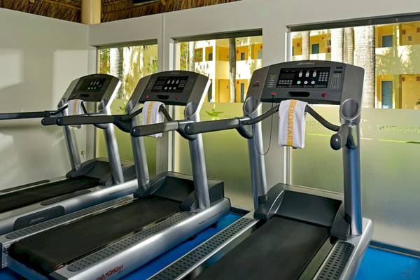 Drei Laufbänder in einem Fitnessraum des Iberostar Costa Dorada Hotels.