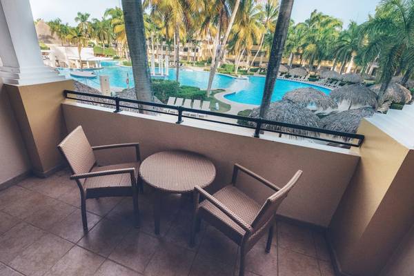 Balkon des Iberostar Costa Dorada Hotels mit Tisch und Stühlen und Blick auf den Pool