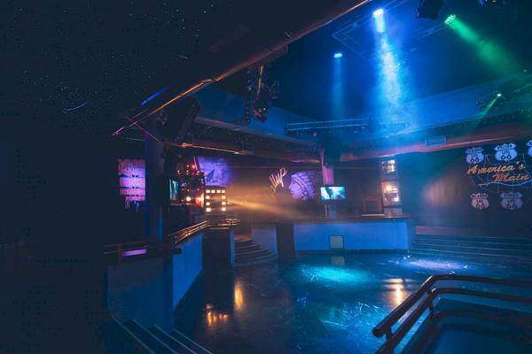 Nachtclub im Iberostar Costa Dorada Hotel mit blauer und grüner Beleuchtung und Musikinstrument-Designs an der Wand.