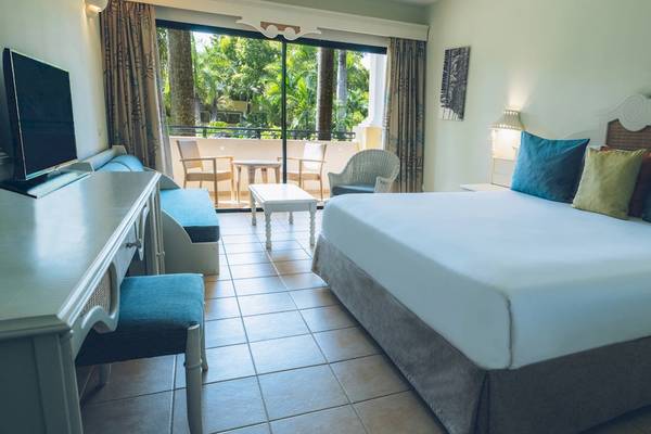 Hotelzimmer im Iberostar Costa Dorada mit großem Bett, Balkon und Terrassenmöbeln.