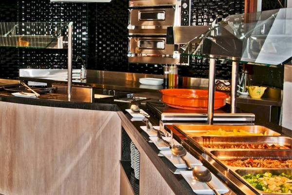 Buffetbereich im BQ Apolo Hotel mit Speisen, Geschirr und Küchengeräten.