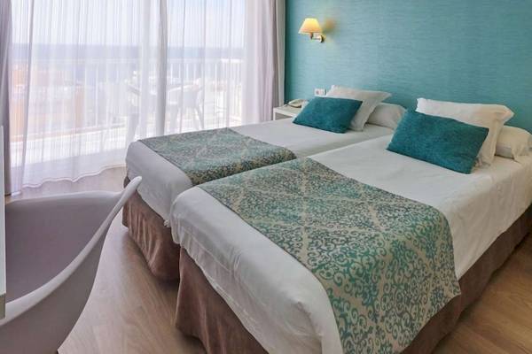 Doppelzimmer mit Meerblick im BQ Apolo Hotel, mit zwei Betten, blauen Kissen und einem Blick auf das Meer.