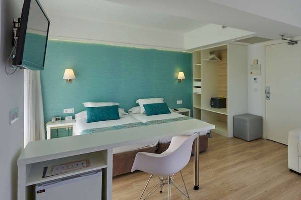 Ein modernes Hotelzimmer im BQ Apolo mit zwei Betten, einem Schreibtisch und einer Couch.
