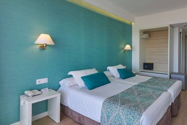 Hotelzimmer im BQ Apolo mit zwei Betten, blauen Kissen und modernen Möbeln.