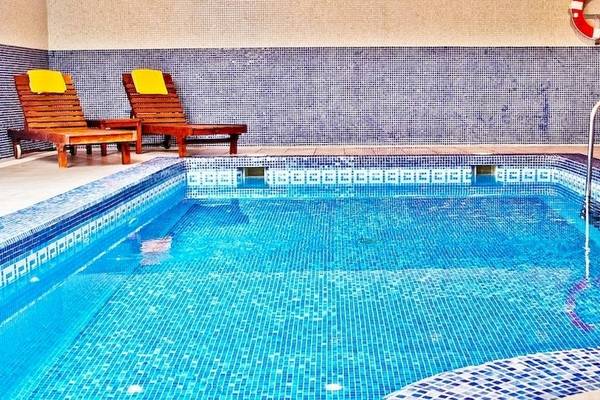 Innenpool des BQ Apolo Hotels mit zwei Liegestühlen und einer Rettungsleine