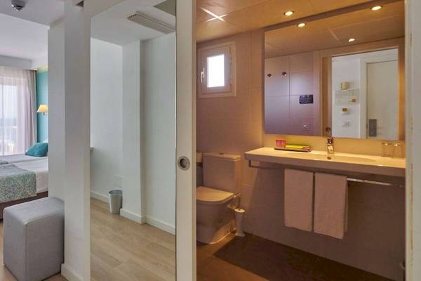 Hotelzimmer im BQ Apolo mit zwei Betten, Schreibtisch, Stuhl, und Meerblick.